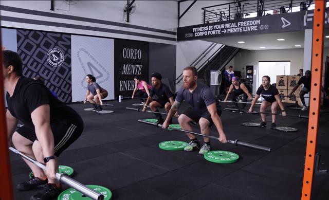 Turma treinando com barras e anilhas